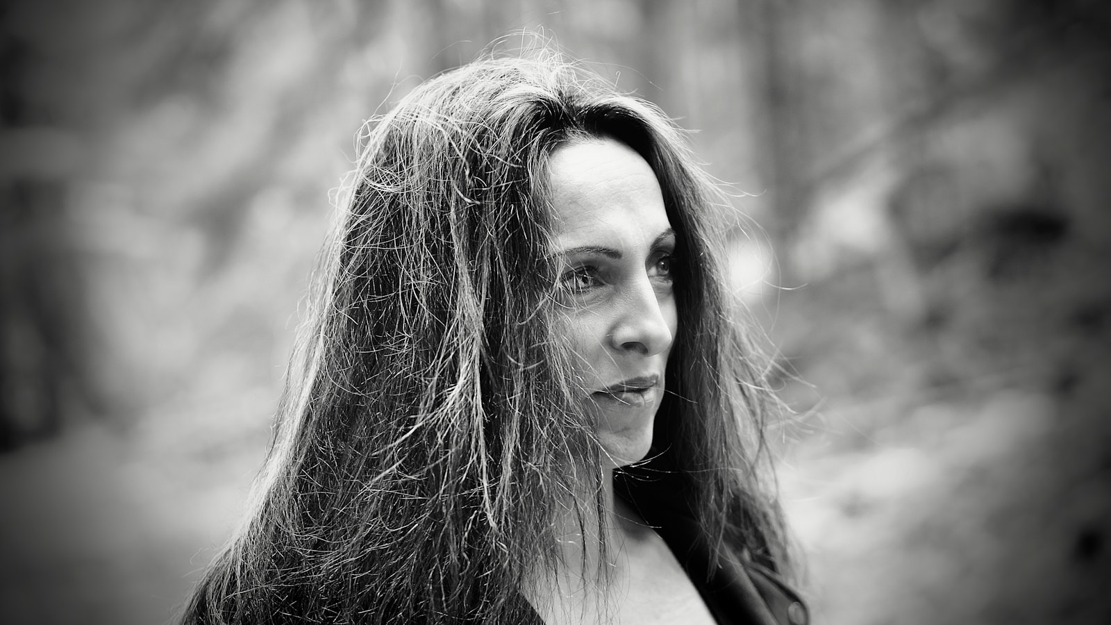 A woman with long hair looks off to the side.